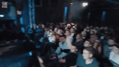 Crowd In Dark Room With Take Over Sign GIF