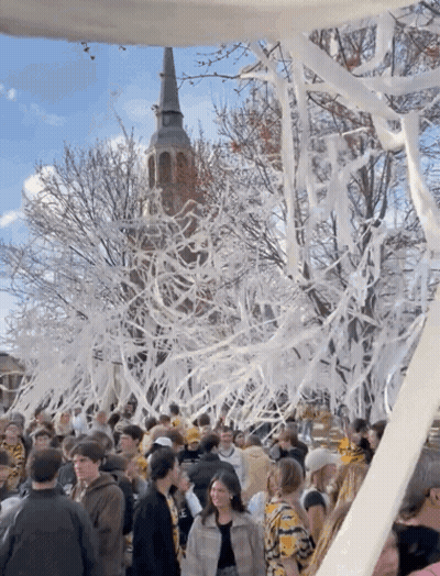 Crowd In Front Of Tower Covered In Tissue Paper GIF