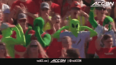 Crowd In Green Alien Costumes With ACCN Logo GIF