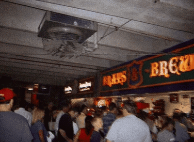 Crowd Of People Under Brau's Brewery Sign GIF