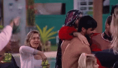 Crowd Surrounding Shirtless Man Hugged By Woman GIF
