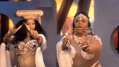 Crowned Woman Next To Woman In Costume GIF
