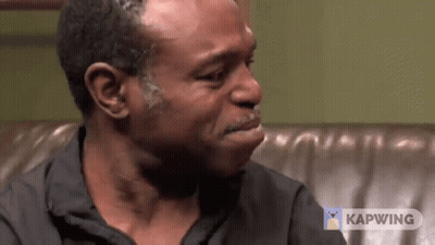 Crying Man Sitting On Couch With Kapwing Logo GIF