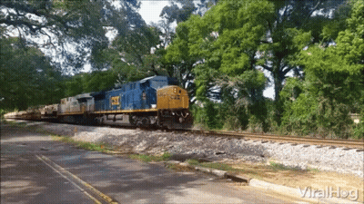 CSX Train Going Down Tracks Near Road GIF