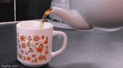Cup Of Tea With Flowers Poured From Teapot GIF