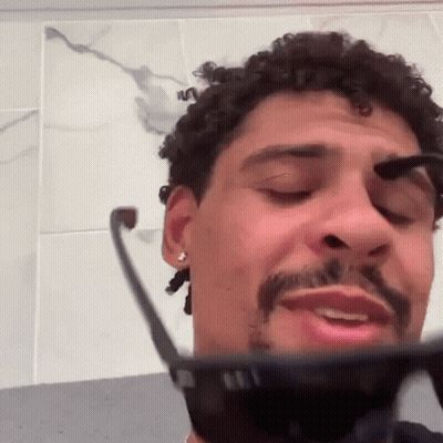Curly Haired Bearded Man Brushing Eyebrows With Sunglasses GIF
