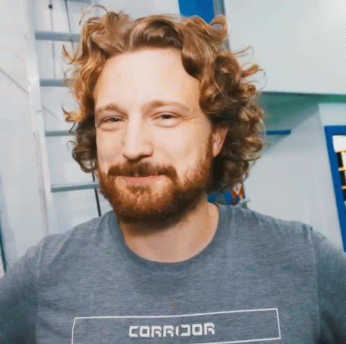 Curly Haired Bearded Man In Gray Corridor Shirt GIF