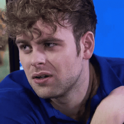 Curly Haired Man In Blue Shirt Staring GIF