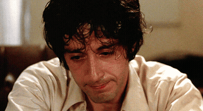 Curly Haired Man In White Shirt Looking Down GIF