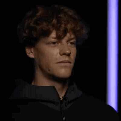 Curly-Haired Man Making Funny Face In Dark Room GIF