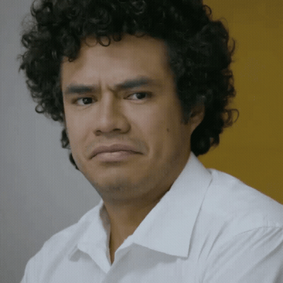 Curly Haired Man Making Serious Face In White Shirt GIF