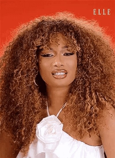 Curly Haired Woman In White Dress And White Flower Necklace GIF