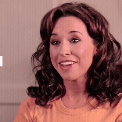Curly Haired Woman Smiling In Yellow Shirt GIF