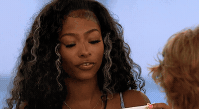 Curly-Haired Woman With Nose Ring Looking Down GIF