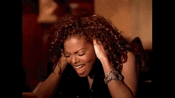 Curly Woman Ear Plugs While Singing GIF