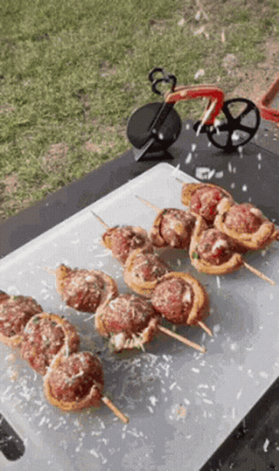 Cutting Board With Meatball Skewers And Pizza Cutter GIF