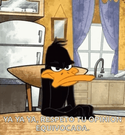 Daffy Duck Is Sitting At A Table In A Kitchen With A Refrigerator In The Background . GIF
