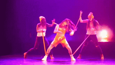 Dancers Performing On Stage With Purple Lighting GIF