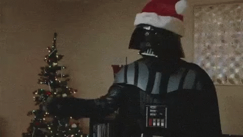 Darth Vader Is Holding A Lightsaber In Front Of A Christmas Tree . GIF