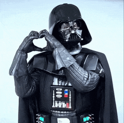 Darth Vader Is Making A Heart Shape With His Hands In A Star Wars Costume . GIF