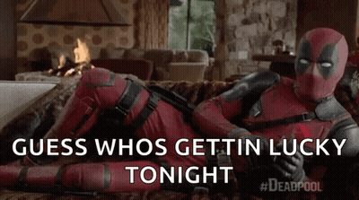 Deadpool Is Laying On A Couch In A Living Room Holding A Rose . GIF