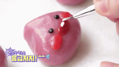 Decorating Purple Marshmallow With Red And White Icing And Fork GIF