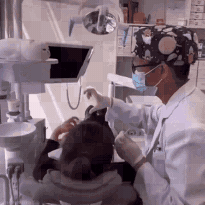 Dentist Examining Child's Teeth With Mask GIF