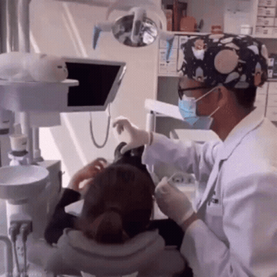 Dentist In Mask And Gloves Examining Patient's Teeth GIF