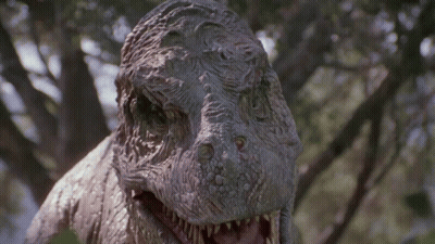 Dinosaur Statue With Open Mouth Looking At Camera GIF