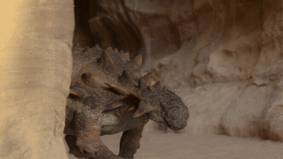 Dinosaur With Spikes Standing In Cave GIF