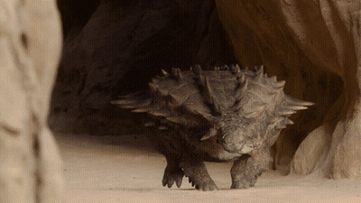 Dinosaur With Spikes Walking On Sand GIF