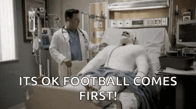 Doctor Examining Man In Hospital Bed Football Comes First GIF