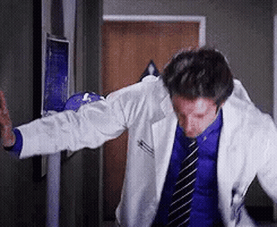 Doctor In Lab Coat Dancing In Hospital Hallway GIF