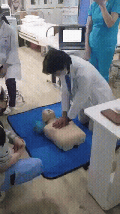 Doctors Practicing CPR On Mannequin In Hospital GIF