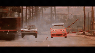 Dodge Charger And Red Sports Car Racing Down City Street GIF