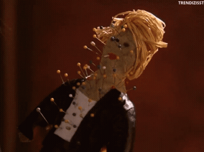 Doll With Pins On Face And Neck GIF
