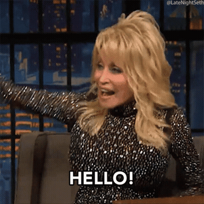 Dolly Parton Is Sitting In A Chair With Her Arms Outstretched And Says Hello ! GIF