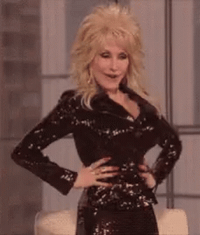 Dolly Parton Is Wearing A Black Sequined Jacket And A Black Dress . GIF