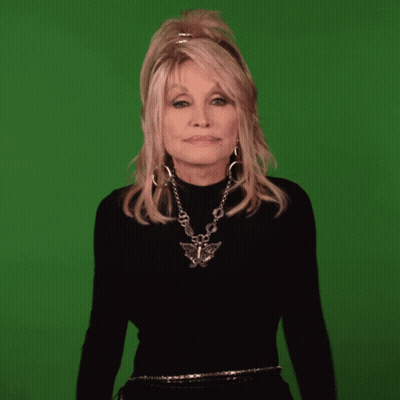 Dolly Parton Is Wearing A Black Turtleneck And A Silver Necklace GIF