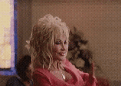 Dolly Parton Is Wearing A Pink Dress And Making A Funny Face . GIF