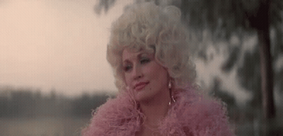Dolly Parton Is Wearing A Pink Fur Coat And A Pink Feather Boa . GIF