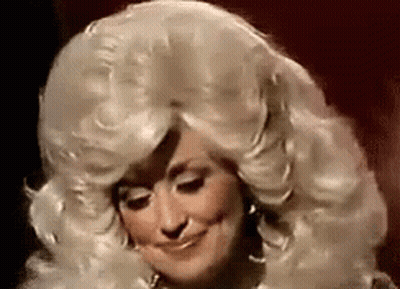 Dolly Parton Is Wearing A Wig And Smiling In A Close Up Of Her Face . GIF