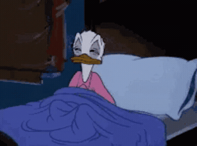 Donald Duck Is Laying In A Bed With A Blue Blanket GIF
