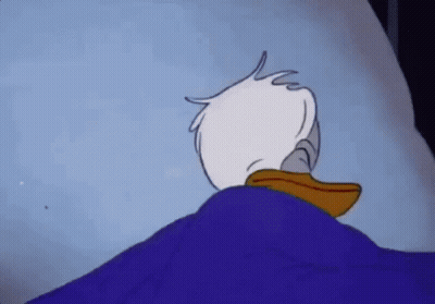 Donald Duck Is Laying In A Bed With A Blue Blanket On Top Of Him . GIF
