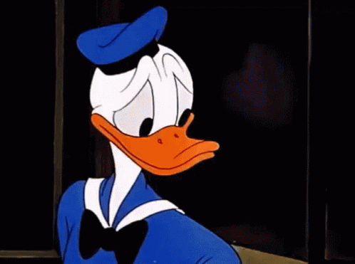 Donald Duck Is Making A Stop Sign With His Hand While Sitting At A Table . GIF