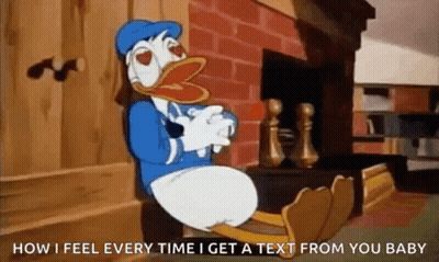 Donald Duck Sitting On Bench By Fireplace With Feet Up GIF