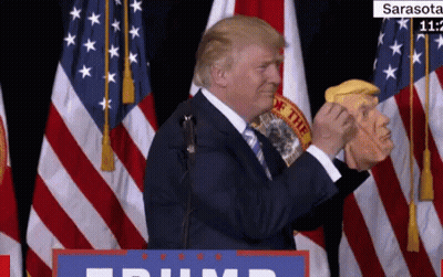 Donald Trump Holds A Mask Of Himself In Front Of A Podium That Says Trump GIF