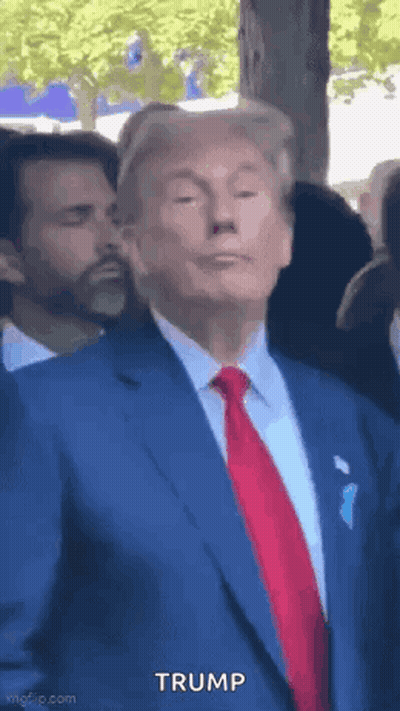 Donald Trump in Blue Suit and Red Tie Before Crowd