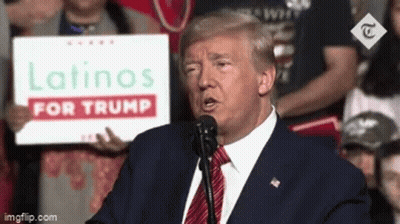 Donald Trump Is Giving A Speech At A Campaign Event While Holding A Sign That Says Latinos For Trump . GIF