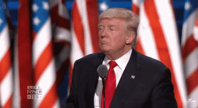 Donald Trump Is Giving A Speech In Front Of A Microphone While Wearing A Suit And Tie . GIF